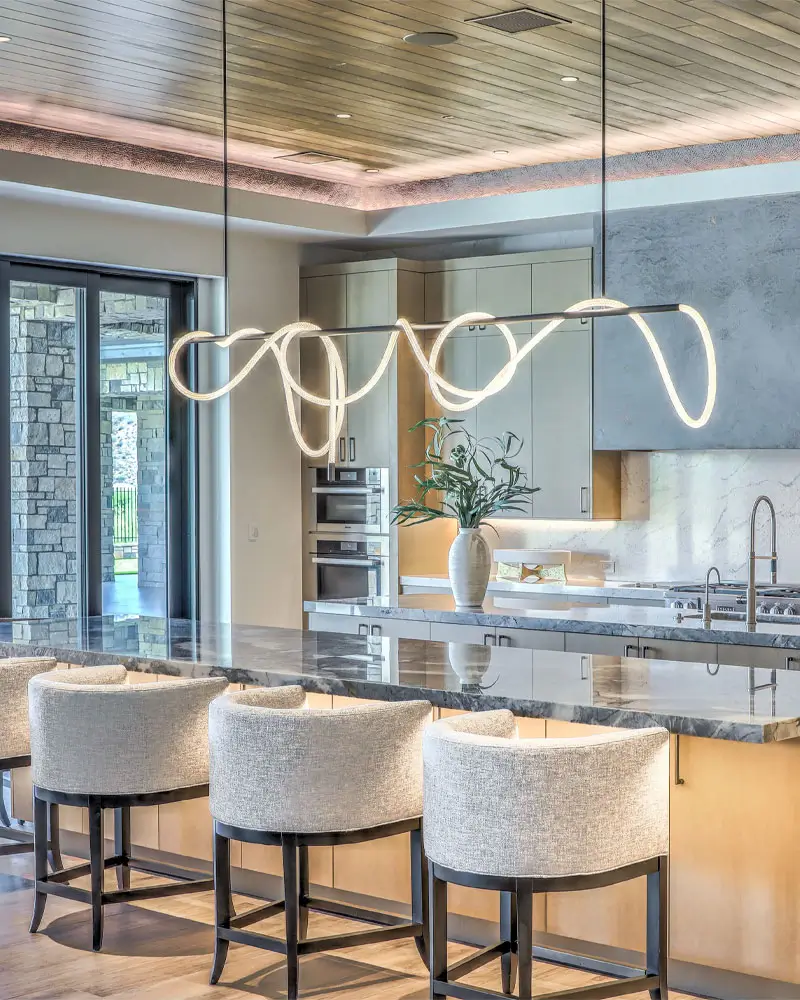 Quartz countertop and island in a bright kitchen with pale cabinetry